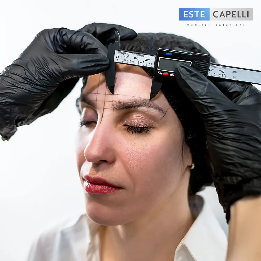 Injerto de cejas precio: especialista mide la distancia entre las cejas con un calibre digital durante el diseño